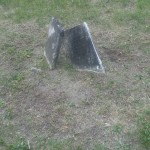 A pair of broken concrete pieces lying on the ground, showcasing rough edges and a weathered surface